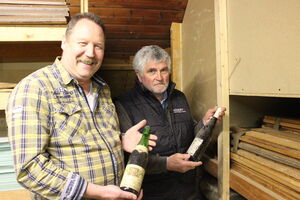 Klaus Friedmann und Helmut Senßfelder mit zwei Flaschen aus dem Weinfund